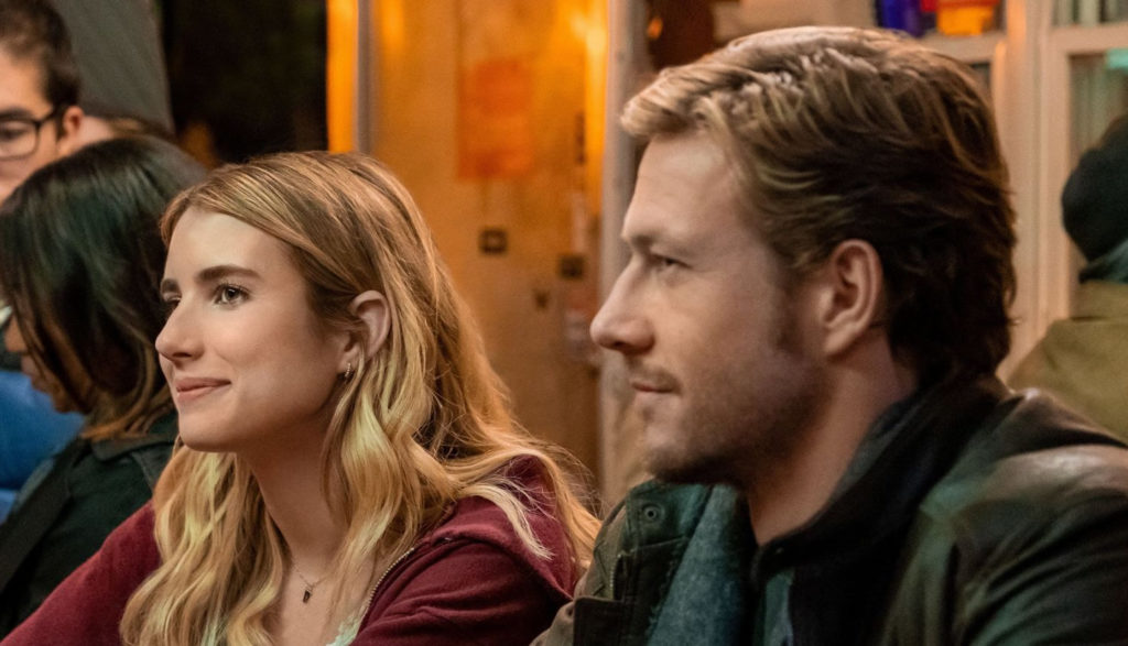 A man and a woman sit next to each other at a bar.