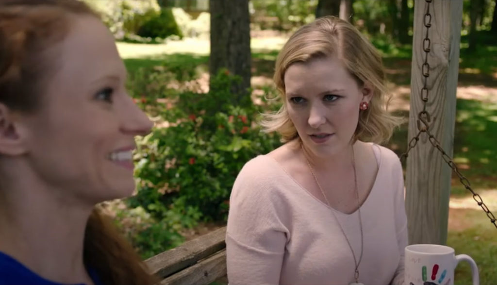 Two women talk on a porch swing.
