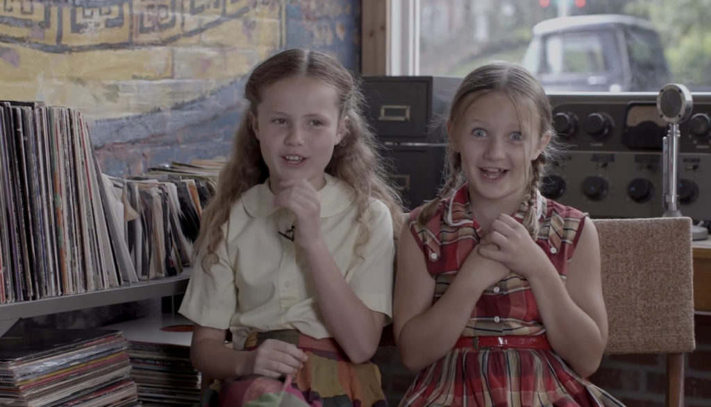 Two young girls laugh together.