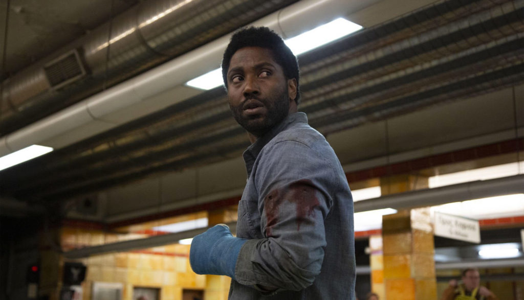 An injured man stands in a subway