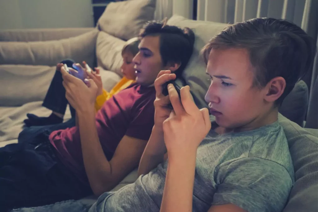 Three boys on cellphones sitting on the couch|Girl with cell phone||4 kids shocked at what they see on their friend's cell phone